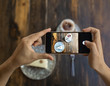 © Hernandez And Sorokina/ADDICTIVE STOCK - Unrecognizable woman taking photo by smartphone of piece of cake on plate with ornament and served coffee on wooden table