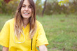© Shotmakers - Retrato de enfermera joven sentada en parque vestida con uniforme amarillo