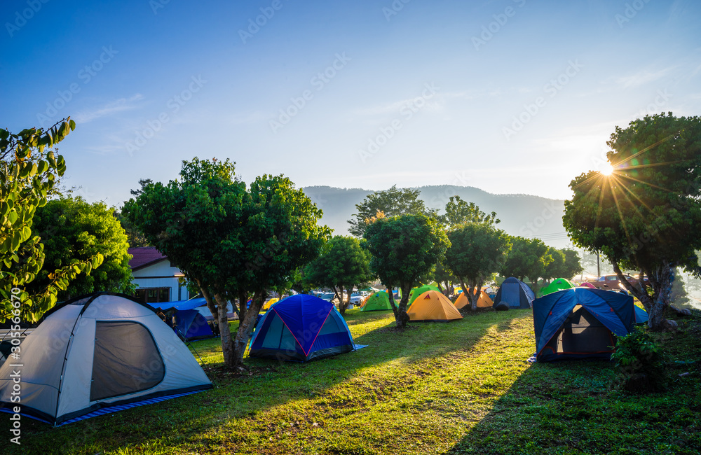 Camping and tent in nature park with sunrise - obrazy, fototapety, plakaty 