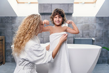 Lovely Attractive Young Mother With Her Handsome Son In Modern Stylish Bathroom Dressing Gown And White Towel.