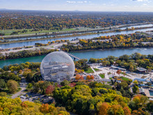 Aerial view of Montreal, Quebec, Canada showing architectural landmark Biosphere Environment Museum and maple trees changing color in fall season.