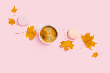 Cup of coffee with marshmallow and maple leaves.