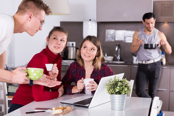 Poster - Girls listening guy in kitchen of hostel