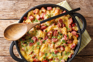 Strata bread casserole with ham, onions, cheese and eggs close-up in a pan. Horizontal top view