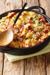 Tasty American breakfast strata with ham, bread, onions, cheese and eggs close-up. vertical