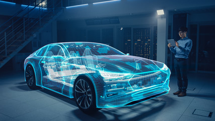Fototapete - Automotive Engineer Working on Electric Car Chassis Platform, Using Tablet Computer with Augmented Reality 3D Software. Futuristic Atomative Facility: Virtual Design with Mixed Technology Application.