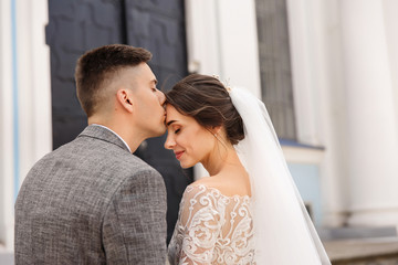 Groom gently kisses bride on forehead after wedding ceremony