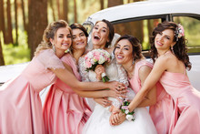 Wedding Photography Of Happy Bride And Bridesmaids In Pink Dresses Embracing With Smile On Wedding Day