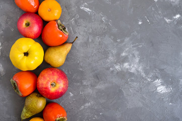 Wall Mural - Different seasonal fruits on a concrete background. Source of vitamins and health. Healthy eating concept. Copy space.