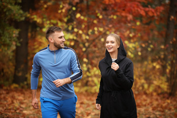 Canvas Print - Loving young couple running in autumn park