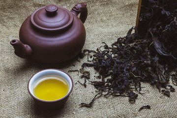 Tea set, teapot, dry tea on fabric background