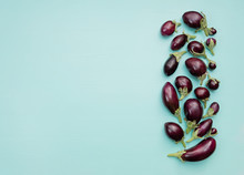 Eggplants Of Different Sizes On A Wooden Background With Mint Color. Top View, Flat Lay.