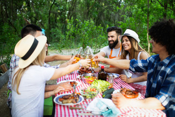 Group of friends camping and having a barbecue in nature