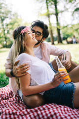 Wall Mural - Happy couple on vacation. Lovers enjoy each other in the park, picnic