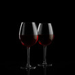 Two red wine glasses on a black background
