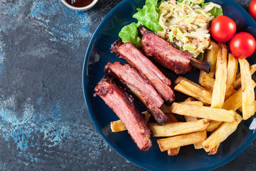 Wall Mural - Spicy barbecued pork ribs served with french fries