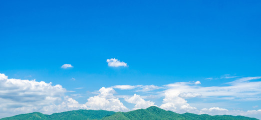 Wall Mural - blue sky and white cumulus clouds over green mountain. beauty in nature. white fluffy clouds. tropic