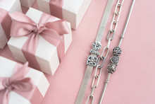Gift Boxes Wiyh Powdery Ribbon. Powdery Background. Silver Bracelet With Charms. Gift Box For The New Year And Christmas. Best Gift For Valentines Day And Mothers Day.