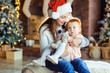 © Studio Romantic - A girl in is holding a sister in her arms at Christmas.