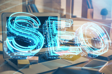 Multi exposure of table with computer and seo drawing hologram. Search optimization concept.