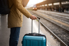 A Young Man With A Blue Suitcase Is Waiting For The Train. Train Station.