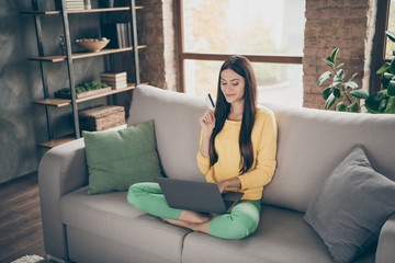 Sticker - Full length photo of positive cheerful girl sit divan legs crossed use computer want buy new dress use plastic card easy payment concept in house indoors