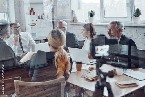 Fotomural Successful business team discussing strategy while filming staff meeting in the