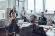 © gstockstudio - Confident businessman conducting a presentation while having staff meeting in the board room