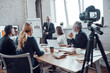 © gstockstudio - Successful business team listen a man which conducting presentation while filming staff meeting in the board room