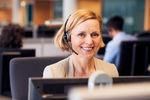 Portrait Of Mature Businesswoman Wearing Telephone Headset Working In Customer Services Department