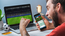 Guy Being Happy Winning A Bet In Online Sport Gambling Application On His Mobile Phone