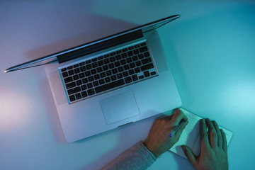 Aufkleber - Beautiful silver laptop and notebook, pen in the color light on a table and night background. Top view.