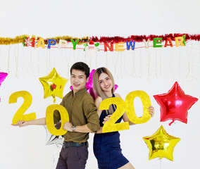 Asian men and young women Hold the number two thousand and twenty in your hand. Happy new year concept