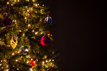 Closeup Of Christmas Tree With Lights, Balls And Decorations, Dark Background