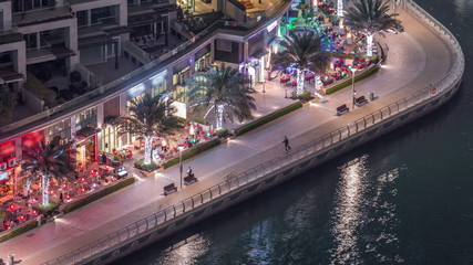 Waterfront promenade in Dubai Marina aerial night timelapse. Dubai, United Arab Emirates