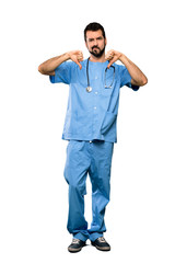 Wall Mural - Full-length shot of Surgeon doctor man showing thumb down over isolated white background