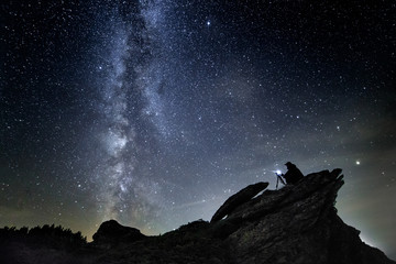 photographer night sky in mountains with camera in tripod