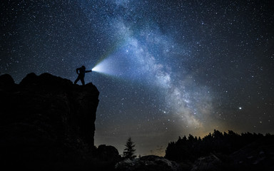 Wall Mural - brave guy in night mountains alone with flashlight