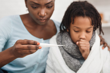 Close-up of afro woman with daughter having cold