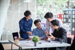 © amnaj - Group of young asian business people working and brainstorming and exchanging ideas at the meeting.