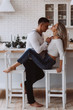 © dimadasha - Romantic christmas evening of a young couple. New year love story. Photo session of lovers in the kitchen.