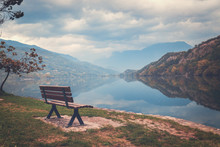 Wooden Bench By The Lake In Focus. Lago Di Cavedine. Italy. Arco