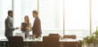 © Prostock-studio - Successful businesspeople talking together in front of office windows