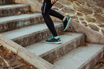 Wall Mural - Stock photo of a young woman climbing stairs while running