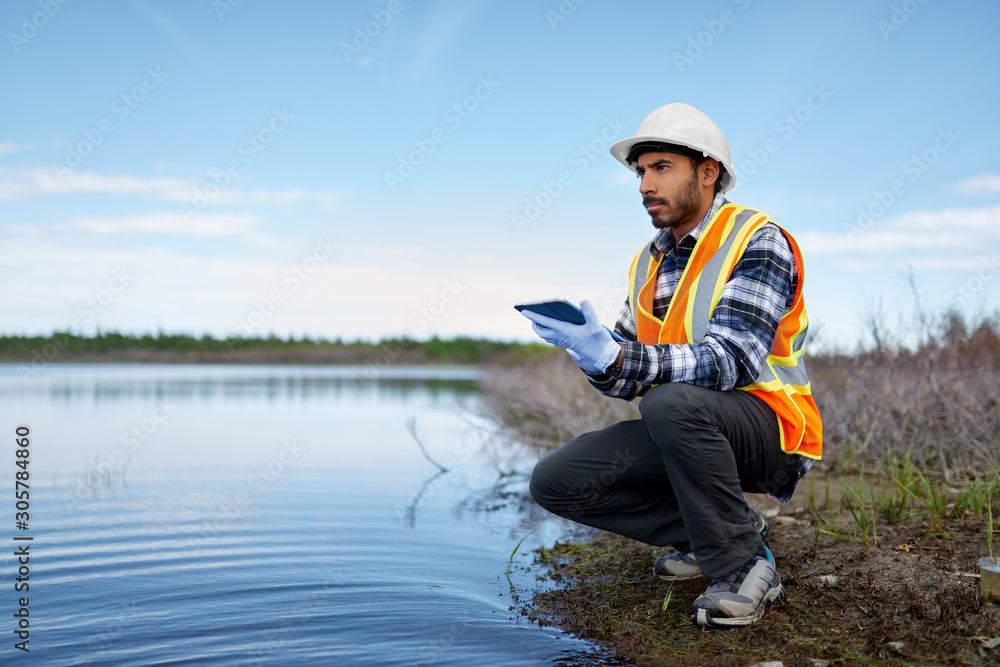 Marine biologist analysing water test results on a tablet in Can - obrazy, fototapety, plakaty 