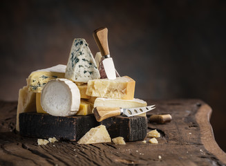 Wall Mural - Assortment of different cheese types on wooden background.