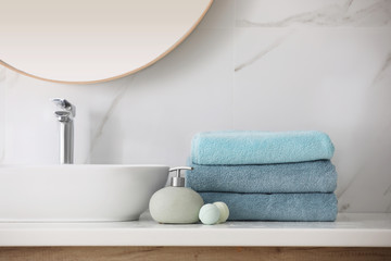 Wall Mural - Stack of fresh towels, soap dispenser and bath bombs on countertop  indoors