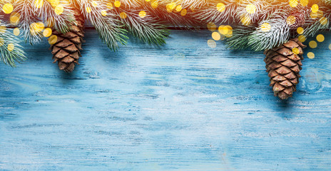 fir covered with snow and christmas decor on a blue wooden table. christmas or new year holiday back