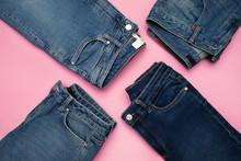Several Pairs Of Blue Denim Jeans On Pink Background