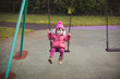 toddler girl playing swing at winter playground,Northern Ireland